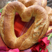 heart-shaped baguette on red cloth with rose