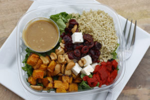 salad with butternut sqiash, cashews, dried cranberries, feta cubes, roasted red pepper, and quinoa on top