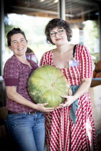 two women holding a large squash