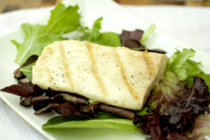 a piece of grilled mahi mahi on a bed of lettuce