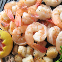 cooked shrimp with cocktail sauce in a lemon rind