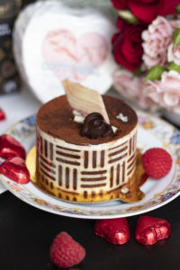 pastry with chocolate on top, with roses in back