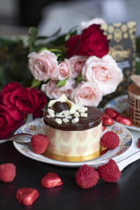 pastry with chocolate on top, with roses in back