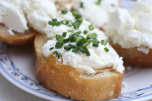 goat cheese on a slice of French baguette, sprinkled with chives