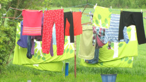 laundry hanging on a line outdoors with a grassy background