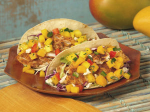 tacos on a plate; they contain catfish and a salsa with mangos and red peppers