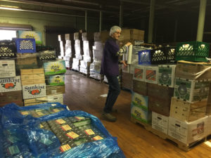 James wrapping plastic around a pallet of food