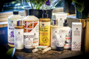 many bottles of Alaffia lotion, soap, shampoo, lip balm