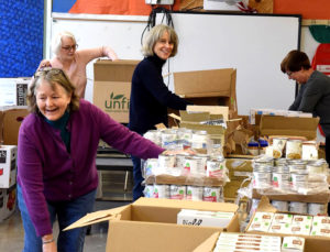 women in a classroom with boxes of food