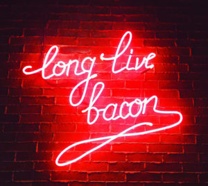 glowing neon sign that reads Ling Live Bacon
