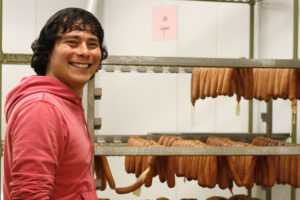 a man with a rack with hot dogs hanging from it