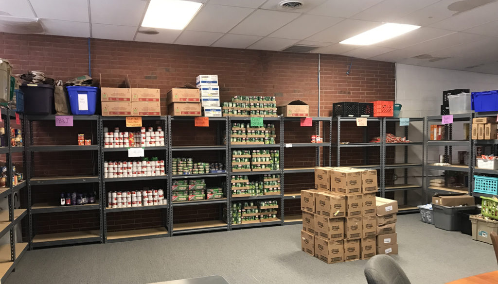 shelves in TABLE's office, with only some sections of cans and many empty sections