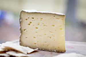 a wedge of cheese with small holes