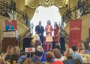 Brenda accepts award on grand staircase with Triangle Business Journal representatives