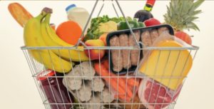 a shopping basket filled with groceries including fruit, milk,. eggs, and meat
