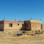 half-built health center on hillside under wide sky