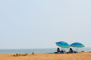 people sitting under umbrellas on a beach