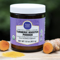 Weaver Street brand turmeric powder in a jar iwth some sliced turmeric root