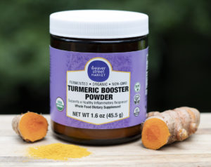 Weaver Street brand turmeric powder in a jar iwth some sliced turmeric root