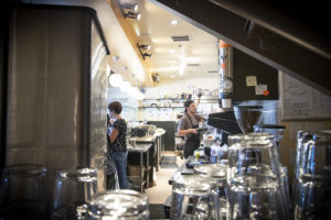 workers behind counter in restaurant, taken oven stacks of clean glasses