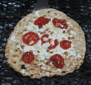 pizza with cheese and tomato on grill