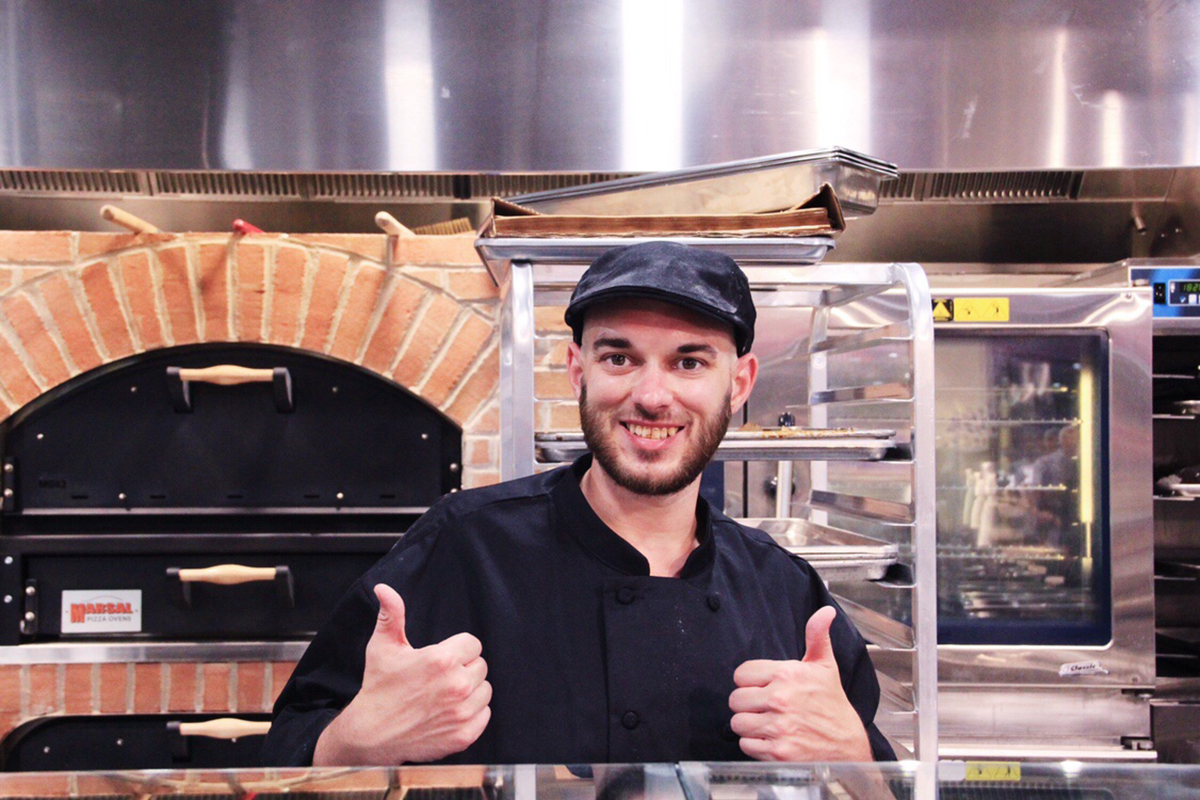 man working at pizza oven, giving thumbs up, Weaver Street Raleigh