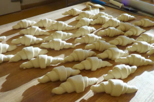 raw croissants on wooden table