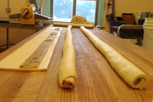 rolls of dough and one long flat sheet of dough with paste filling laid down the center