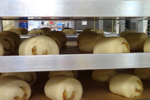 rolled croissant dough with almond filling on pan