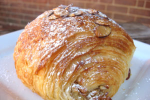 baked almond croissant with sprinkled powdered sugar on top