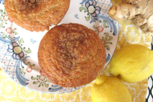 aerial view of muffins on plate with whole lemons and ginger root beside them