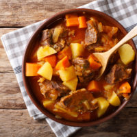 delicious stew estofado with beef and vegetables in a bowl close-up. Horizontal top view from above