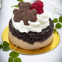 small pastry cake with whipped cream on top and shamrock-shaped cookie
