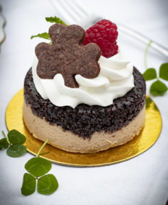 small pastry cake with whipped cream on top and shamrock-shaped cookie